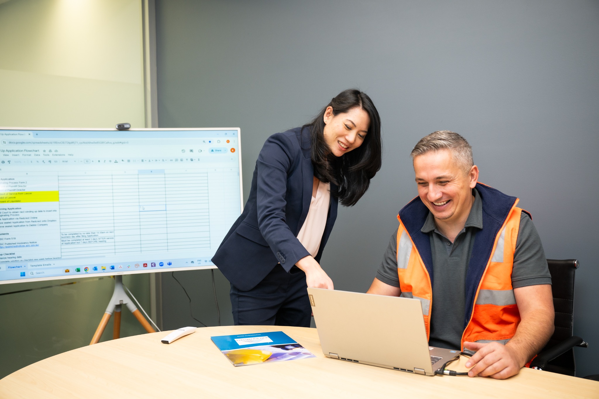 Ping and Bojan reviewing documents at a laptop